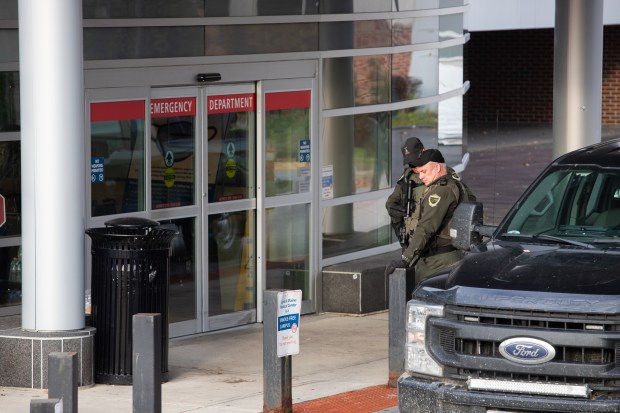 Law enforcement armed with long rifles stand at the entrance to the emergency department entrance of Central Maine Medical Center on Thursday, Oct. 26, 2023, after a mass shooting in Lewiston, Maine.