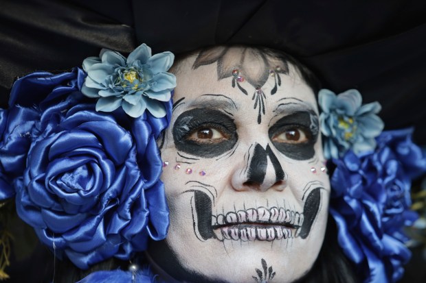 A woman dressed as a "Catrina" parades down Mexico City's iconic Reforma avenue during celebrations ahead of the Day of the Dead in Mexico, Sunday, Oct. 22, 2023. (AP Photo/Ginnette Riquelme)