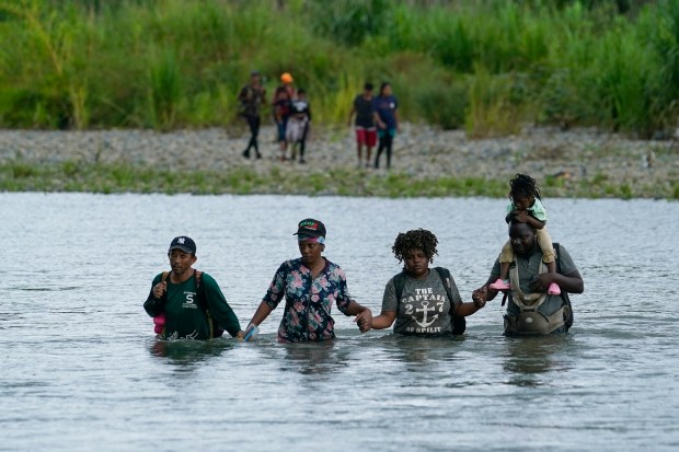Haitian migrants wade across the Tuquesa river after trekking through the Darien Gap in Bajo Chiquito, Panama, earlier this month.