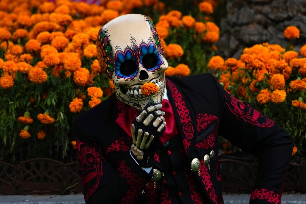 A Mexican mascot dressed as a catrin, a masculine version of the Day of the Dead Catrina, poses for photographers at the Hermanos Rodriguez race track in Mexico City, Thursday, Oct. 26, 2023. The track is hosting the Mexico City Grand Prix which begins Friday. (AP Photo/Fernando Llano)