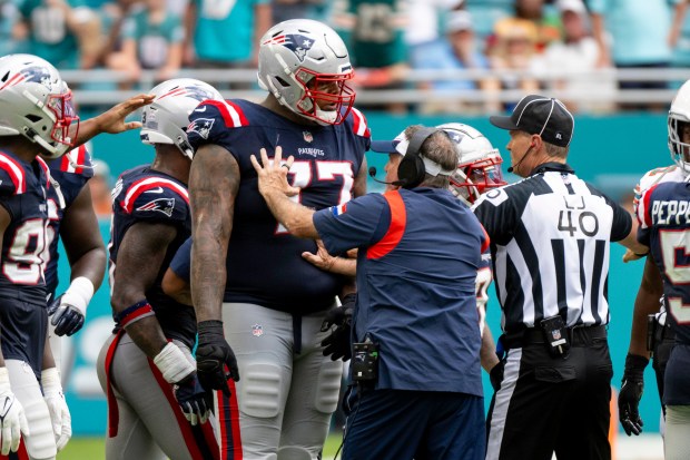 New England Patriots head coach Bill Belichick holds back New England Patriots offensive lineman Trent Brown (77) from joining a scuffle between players on the field during an NFL football game against the Miami Dolphins, Sunday, Oct. 29, 2023, in Miami Gardens, Fla. (AP Photo/Doug Murray)