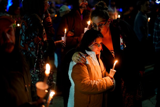 An overflow crowd gathered at a vigil for the victims of Wednesday's mass shootings, Sunday outside the Basilica of Saints Peter and Paul in Lewiston, Maine. (AP Photo/Matt Rourke)