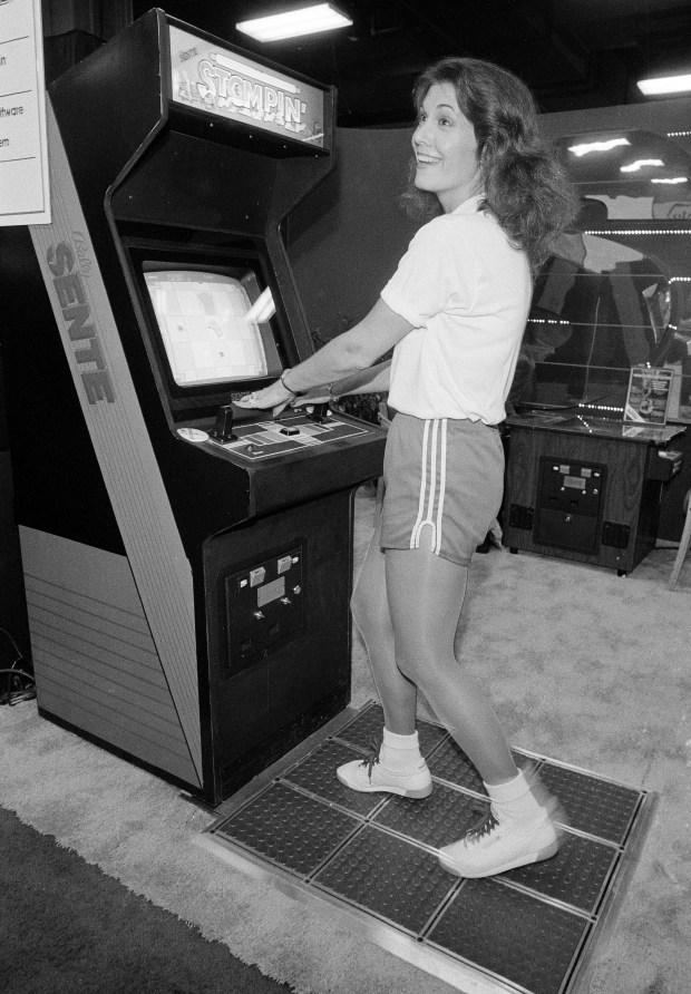 A new, foot-operated video game, played by model Linda Petersen, was introduced by the Bally Sente Co., at the Amusement and Music Operator's Association's 1985 Expo in Chicago, Ill., Nov. 1, 1985. The game, called "Stompin'," is played on a 3-by-3 foot floor mat that corresponds to a picture on the video console. The operator tries to squash armadas of spiders, frogs and mice trying to get at some cheese. (AP Photo/Mark Elias)
