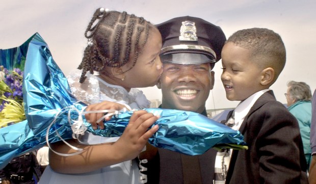 (5/20/04 Boston, MA) Boston Police Academy graduation at the Fleet Pavilion. Officer Winston DeLeon celebrates with children Tanisha, 7 and Winston, Jr. 4.(DSC_0150.JPG - Staff photo by Ted Fitzgerald. Saved in photo Thursday and Daily Photo Archive. (Photo by Ted Fitzgerald/MediaNews Group/Boston Herald)