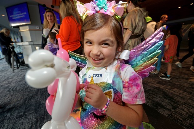 Olivia Recos is thrilled to get a balloon unicorn made by the Revs Joe Howard. (Stuart Cahill/Boston Herald)